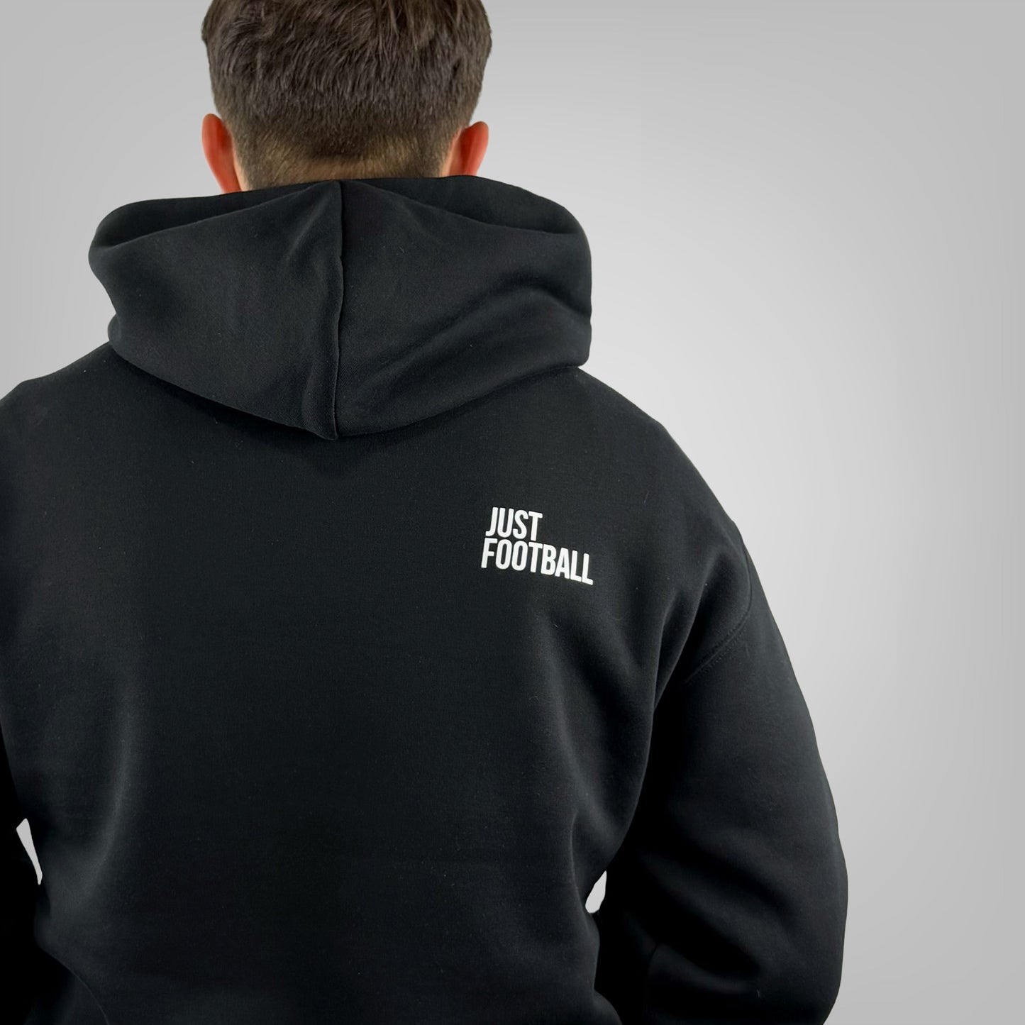 Close up of the Just Football graphic on the ONETWENTI men's relaxed fit hoodie worn by a male model