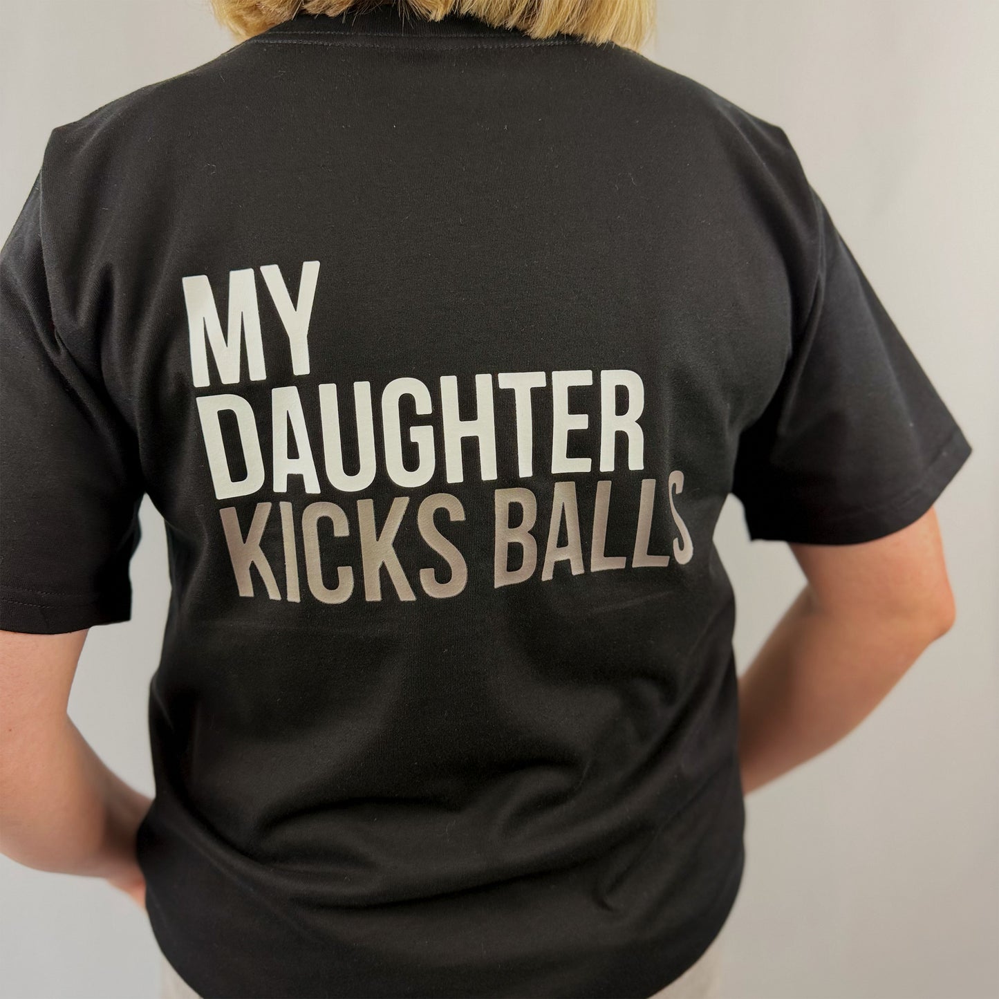 Close up of MY DAUGHTER KICKS BALLS print on black women's t-shirt