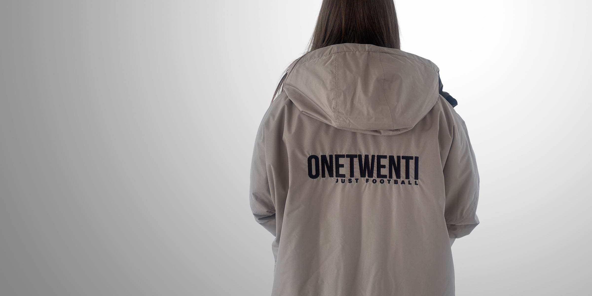 Back of grey ONETWENTI jacket with Just Football text, worn by supporter of the women’s game