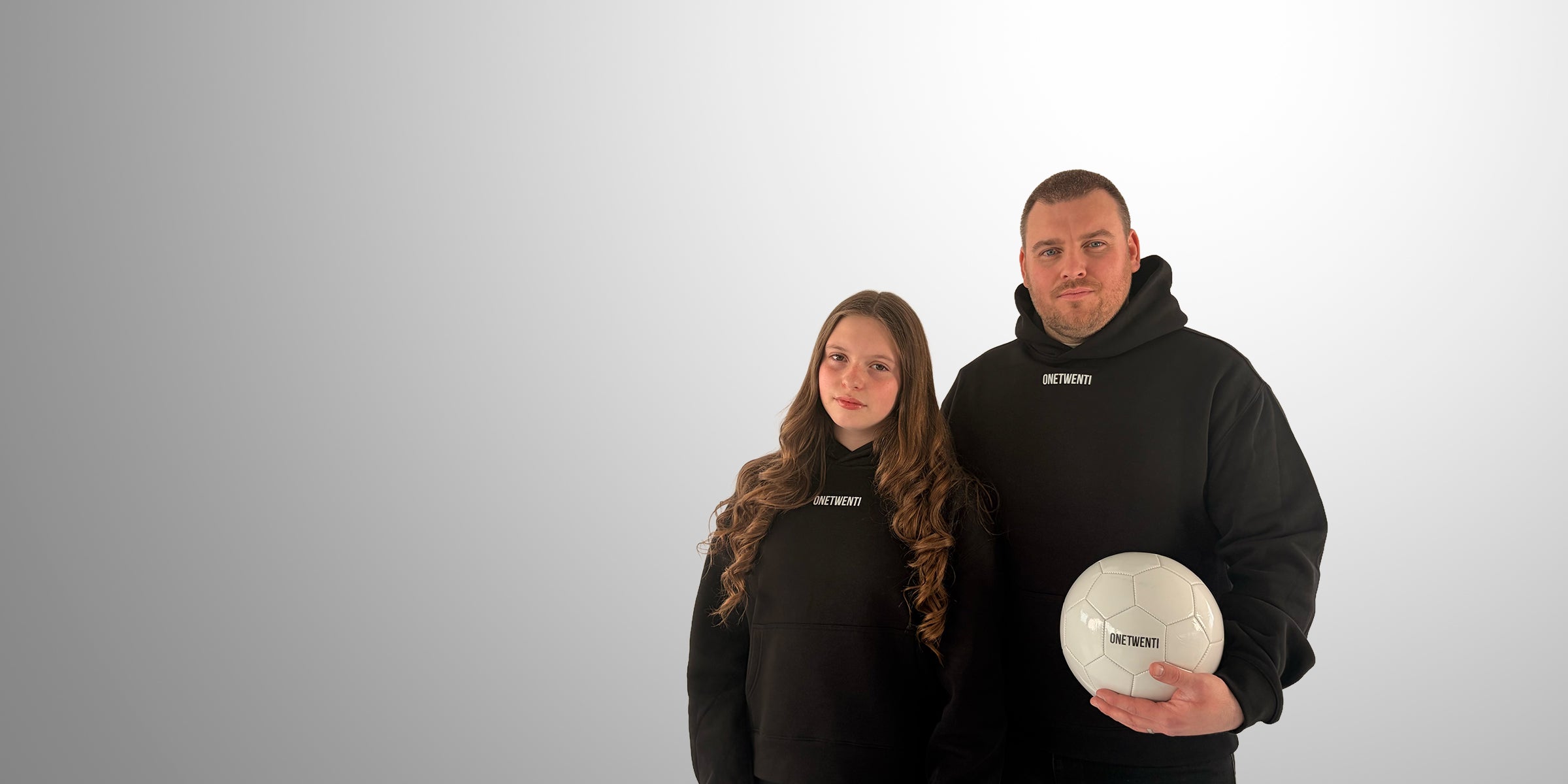 Founder and daughter wearing black ONETWENTI hoodies with football, representing the story behind the women’s football brand
