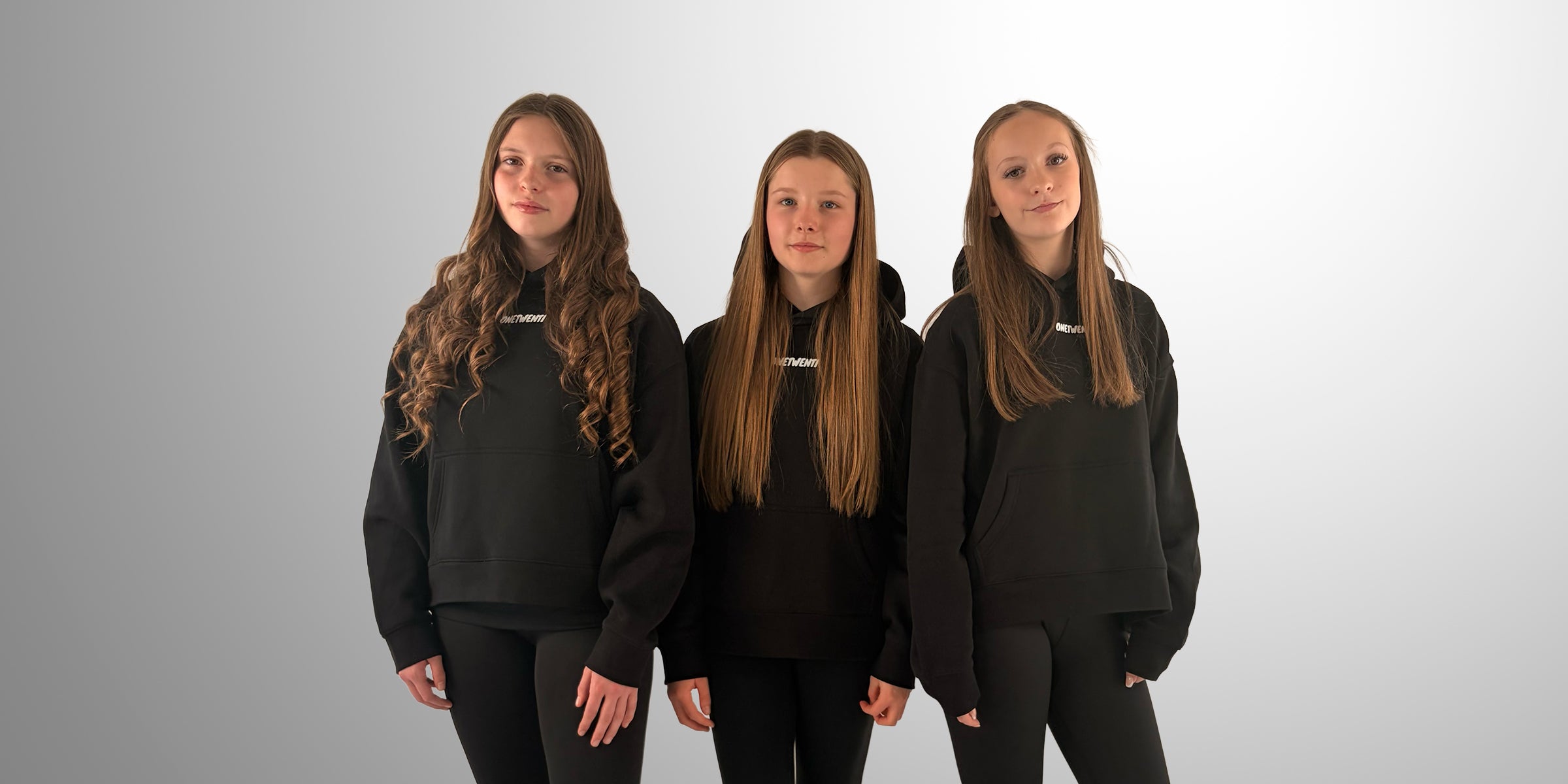 Women’s and girls’ football clothing by ONETWENTI, black hoodies worn by young players in studio