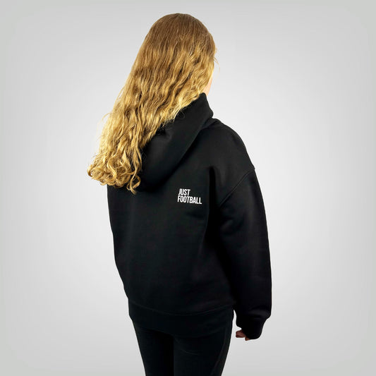 Girl model wearing the ONETWENTI Just Football girls relaxed fit hoodie, rear view