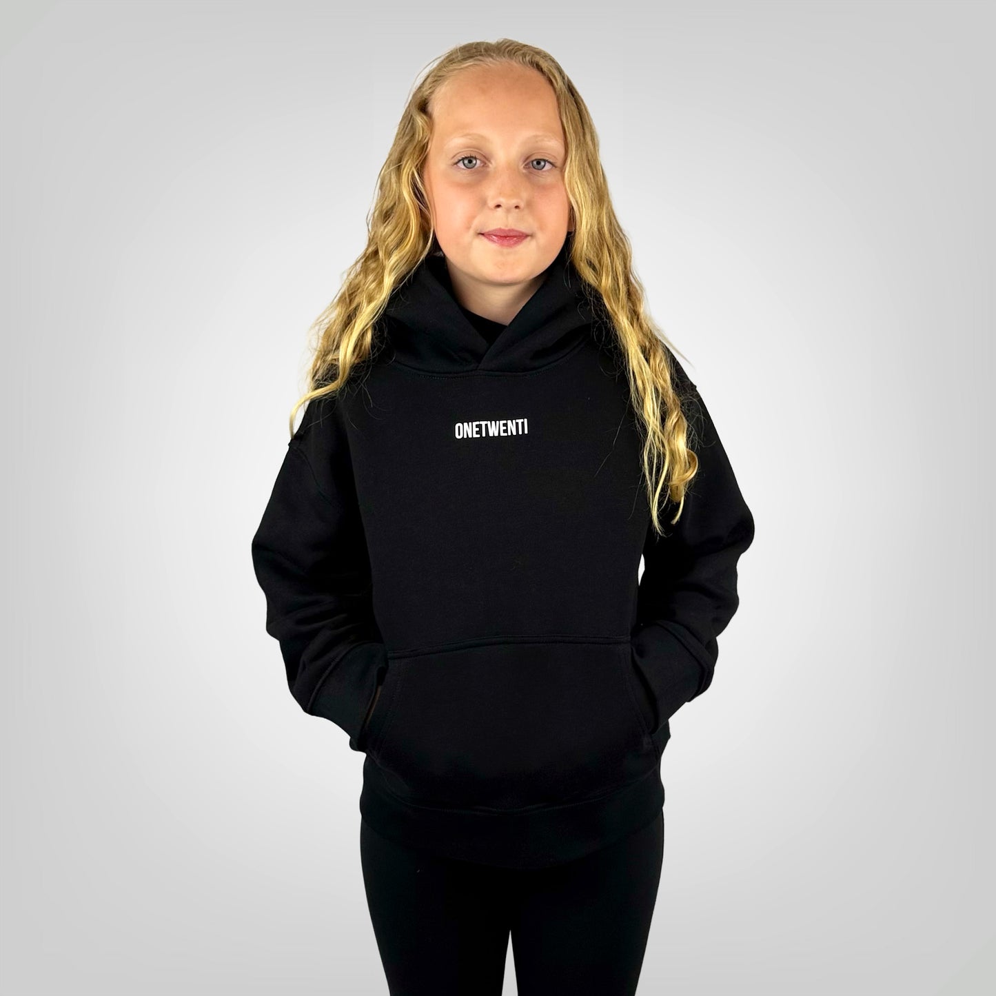 Girl model wearing the ONETWENTI Just Football girls relaxed fit hoodie, front view