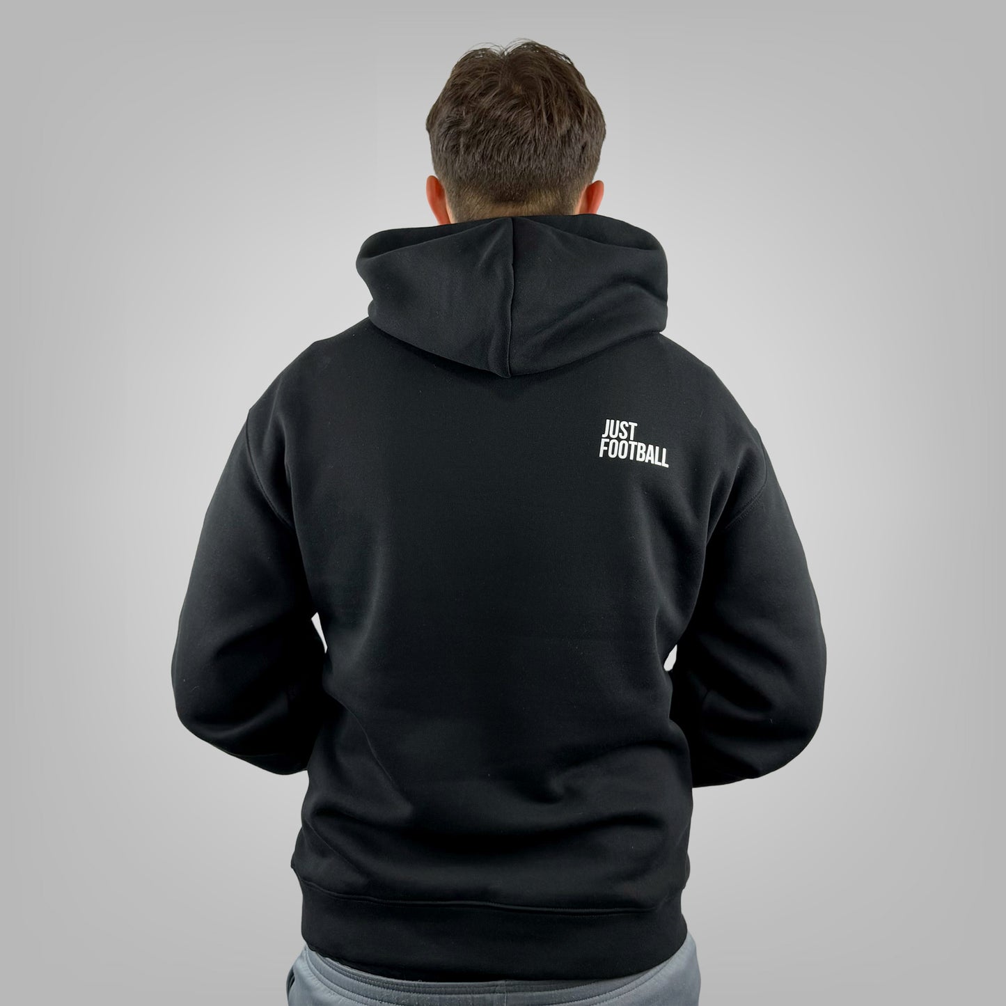 Male model wearing the ONETWENTI Just Football men's relaxed fit hoodie, rear view
