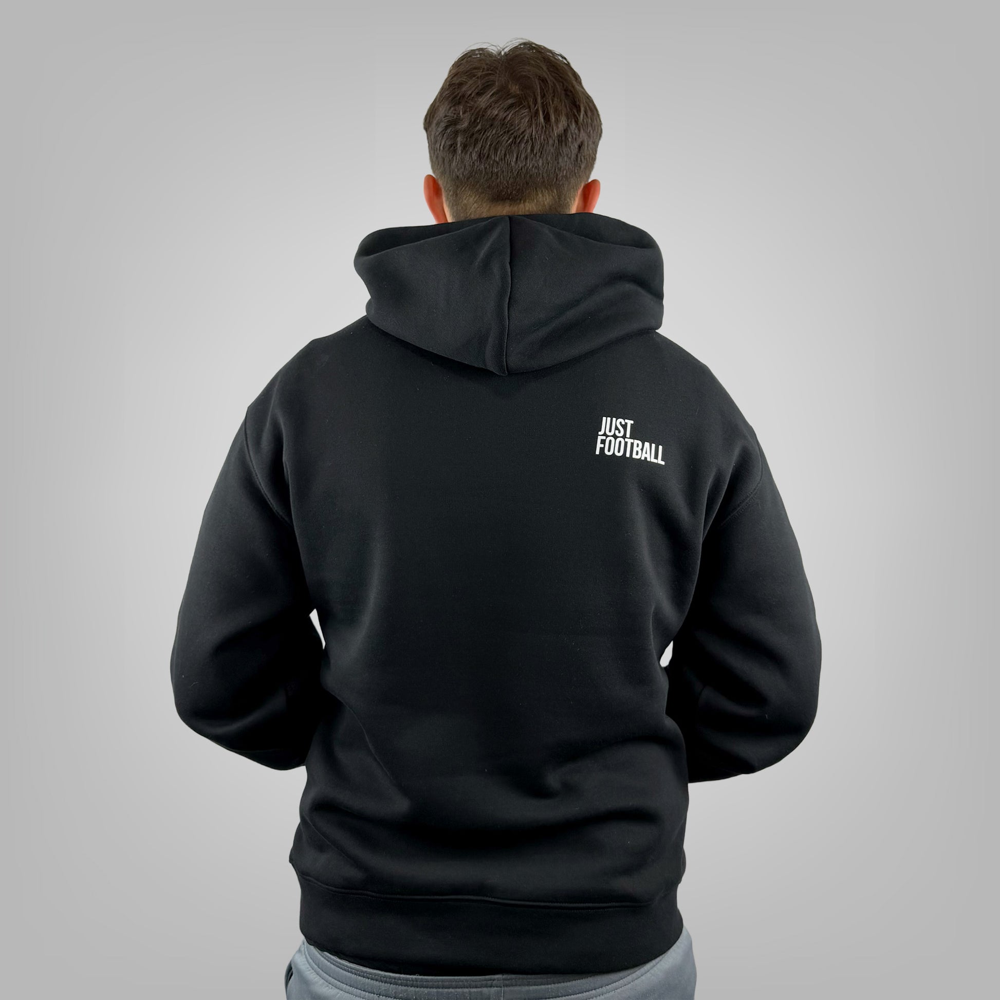 Male model wearing the ONETWENTI Just Football men's relaxed fit hoodie, rear view