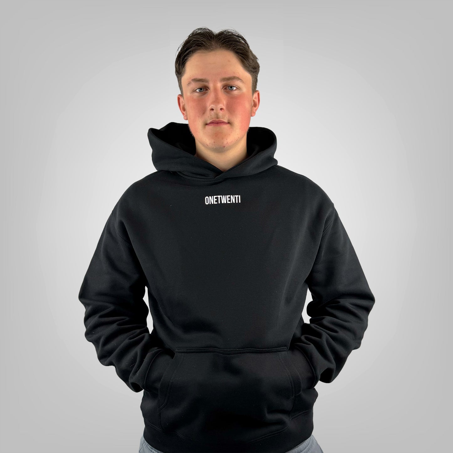 Male model wearing the ONETWENTI Just Football men's relaxed fit hoodie, front view